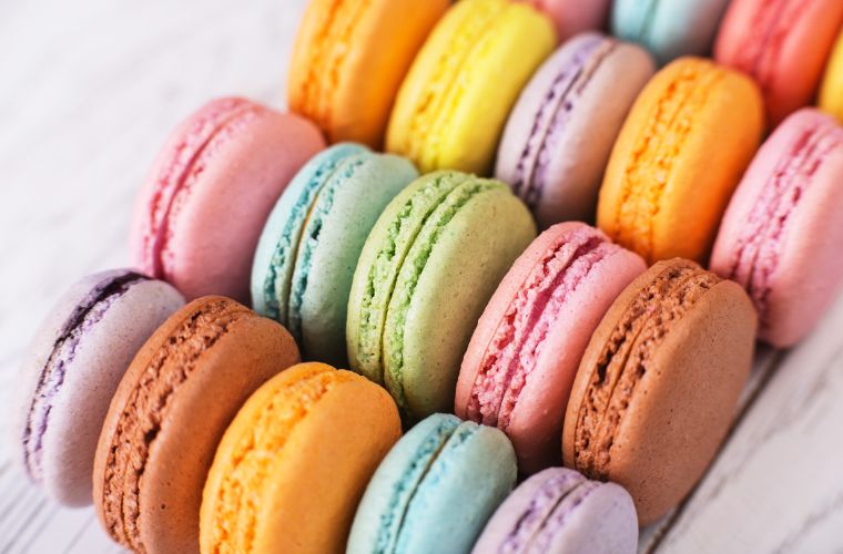 Rengarenk macaronlar, estetik bir şekilde dizilmiş ve tatlı bir Paris anısına hazır. Farklı renklerde ve lezzetlerde olan macaronlar vitrinde sergileniyor.