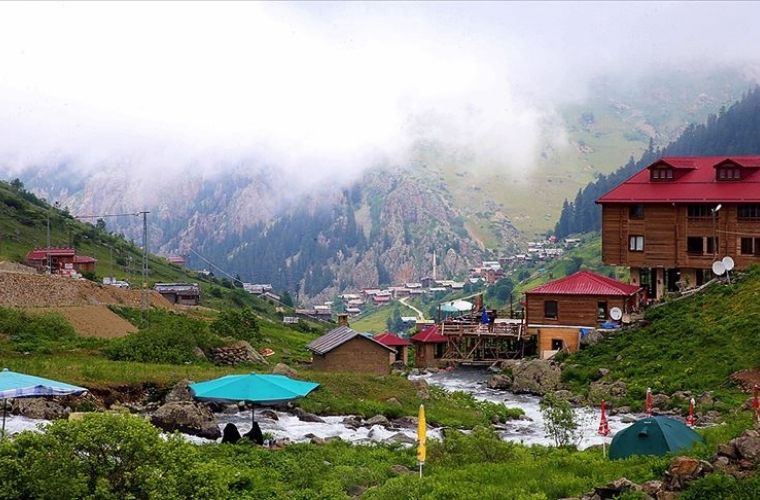 Trabzon Haldizen Yaylası'nda yeşil çimenler üzerine kurulmuş kamp çadırı ve bulut denizi.