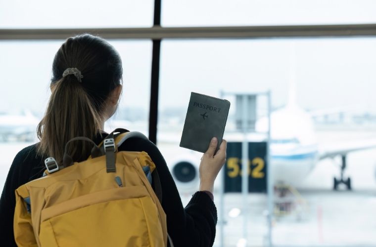 2026 vizesiz ülkeler seyahati için havaalanında bekleyen mutlu gezgin.